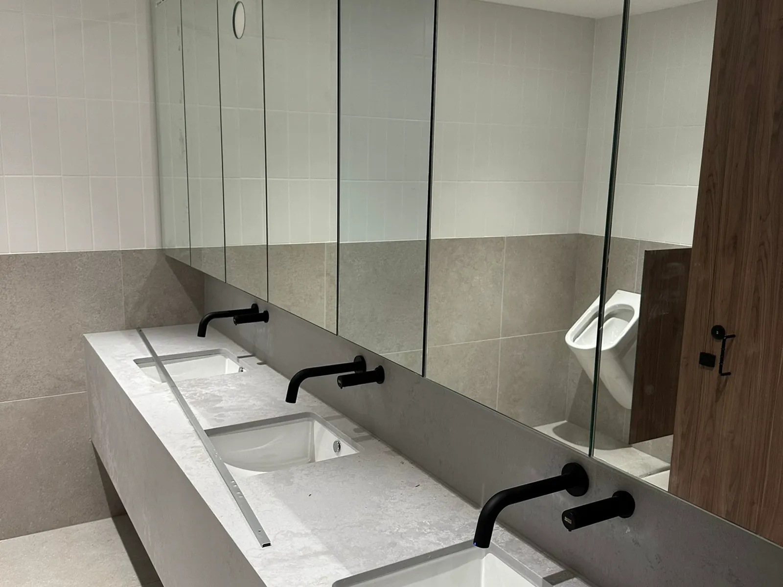 Commercial bathroom amenities with twin basins and matte black wall-mounted tapware, Sydney CBD