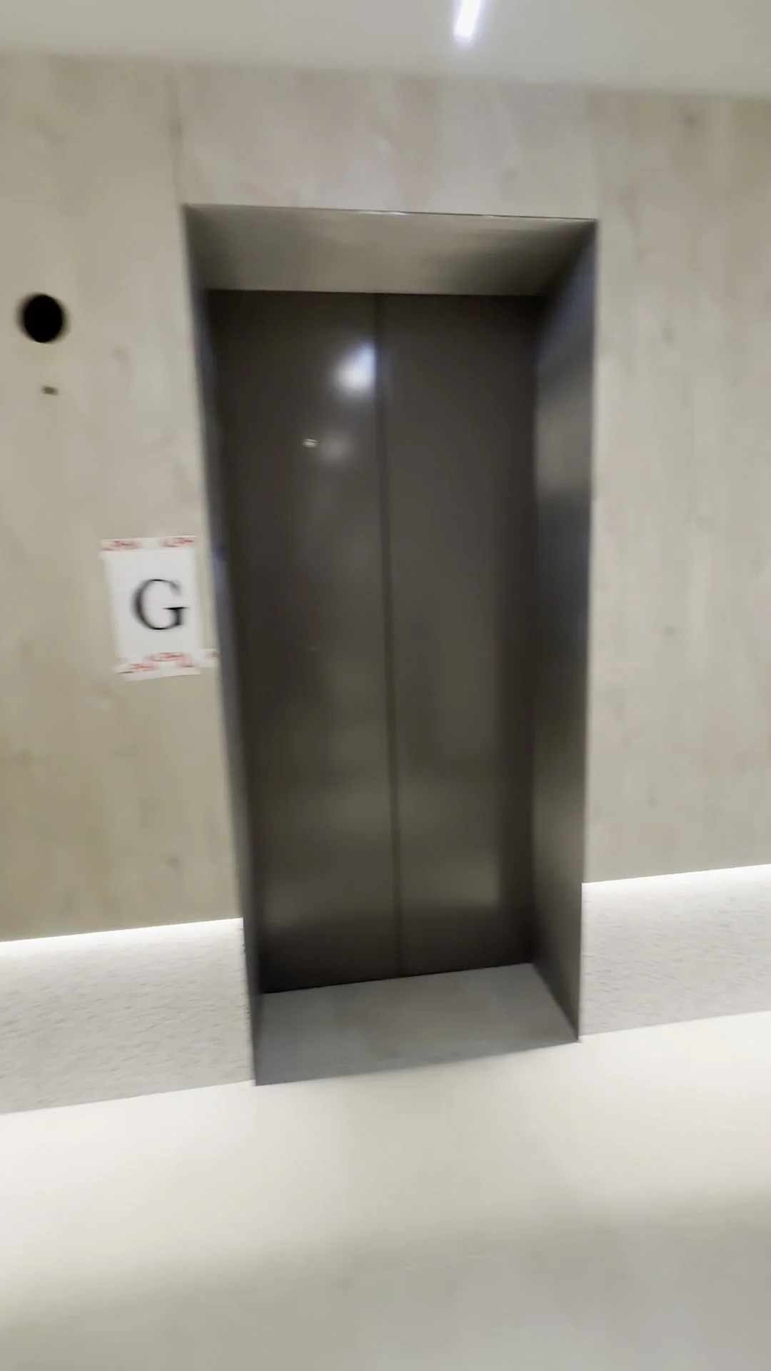 Timber-panelled lift lobby with terrazzo-look skirting in a Potts Point commercial building
