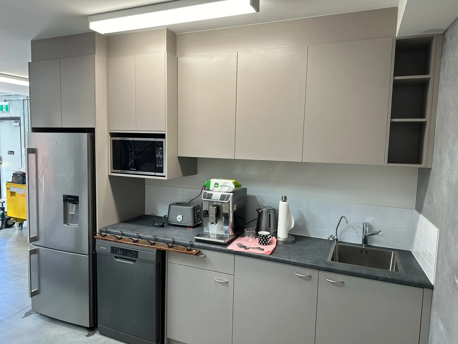 Angled view of the commercial kitchenette cabinetry and appliances in Mosman